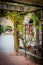 A wooden archway with paved footpath leading toto a vineyard