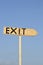 Wooden arrow sign with the word exit. In the background the blue sky.