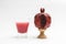 Wooden artificial pomegranate with grains on base, juice in glass