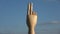 Wooden artist manikin hand rotating on blue sky, 4K