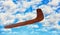 Wooden australian boomerang in flight against of cloudy blue sky