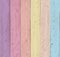 Wooden background of 6 vertical boards painted in pastel shades, in violet, pink, orange, yellow, salmon and blue colors.