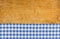 Wooden background with a blue checkered tablecloth