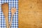 Wooden background with a blue checkered tablecloth and wooden spoon