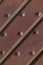 Wooden background dark brown oblique planks with iron rivets