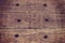 Wooden background of old wooden railway sleeper, rusty hexagon nut or iron screws