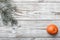 Wooden background. White painted. branch of green fir. Orange. Space for Christmas or New Year.