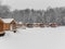 Wooden barbecue houses in a snowy winter park. Pergolas with terraces for outdoor recreation