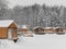 Wooden barbecue houses in a snowy winter park. Pergolas with terraces for outdoor recreation