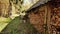 Wooden barn in the village. The wall of the barn is filled with piles of chopped firewood. Autumn time. Shooting in