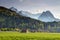 Wooden barns in meadow with jagged Alpspitze, Zugspitze peaks