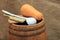 Wooden barrel with ladle and pumpkin on burlap background.