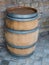 Wooden barrel on marble tile floor, stone wall in background