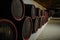 wooden barrels inside the underground tunnels of a winery
