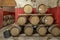 Wooden barriques for wine aging are arranged on three levels in a Tuscan cellar