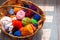 Wooden basket with rainbow natural balls of yarn