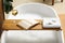 Wooden bath tray with glass of wine, open book, massage stones and towel on tub indoors. Relaxing atmosphere