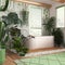 Wooden bathroom in white and green tones with freestanding bathtub. Windows with venetian blinds. Biophilic concept, many