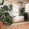 Wooden bathroom in white and orange tones with freestanding bathtub. Windows with venetian blinds. Biophilic concept, many