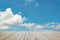 Wooden batten bridge juts out into the expanse of the blue cloud sky