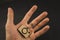 Wooden bauble in the hand of man in the form of a camera on a black background