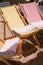 Wooden beach chairs, sun loungers and beach towels on the sandy beach.