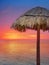 Wooden beach umbrella in golden orange sunset