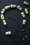 Wooden beads and glass beads on a black thread. Black paper background