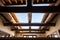 wooden beams cross at the peak of a pueblo house interior