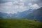 Wooden bench alone at the top of a green hill with foggy layered mountains in the background