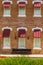 Wooden Bench Below Six Windows With Awnings