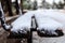 Wooden bench covered with snow in a park waits for companionship. Close up, blur background, banner