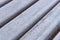 Wooden bench covered with white hoarfrost, close up. Focus in the center, blurred edges.