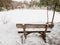 Wooden bench by the frozen blue lake. Winter tracking in popular in Adrspach rocks