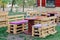 Wooden bench made of pallets for sitting with tables made from coil of electric cable