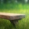 Wooden bench in a meadow with green bright light in garden background of grass and blurred foliage bokeh