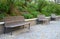 Wooden bench near the edge of the path in the park pedestrian blocks pavement retaining wall low metal frame benches elegant shape