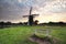 Wooden bench near windmill at sunrise