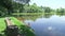 Wooden bench next to a fishing lake with calm water