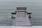 Wooden bench on a pier in front of the Conceicao Lagoon during a rainy day, in Florianopolis, Brazil