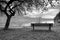 Wooden bench for relaxing on shore. View on Alps mountains with white peaks mirror