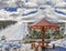 Wooden bench with roof and snow on mountain view ski track point