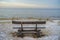 Wooden bench on the sea coast. Winter sunrise