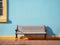 a wooden bench sits against a blue wall