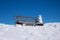 Wooden bench with tiny snowman, blue sky