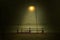 Wooden bench under light lamp by seafront