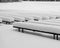 wooden benches covered with a thick blanket of snow, play of light and shadows, rhythm