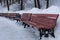 wooden benches stand in a row in the winter in the park