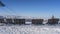 Wooden benches stand on a snowy plateau.