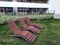 Wooden benches and tables in the yard of a modern house for cozy picnics and gatherings with friends and neighbors. sunbeds made